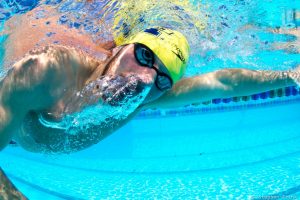 Swimmer exhaling under water while swimming.
