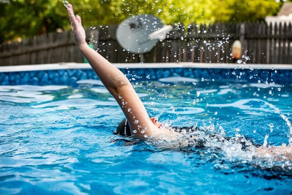 An athlete swimming backstroke in a pool.