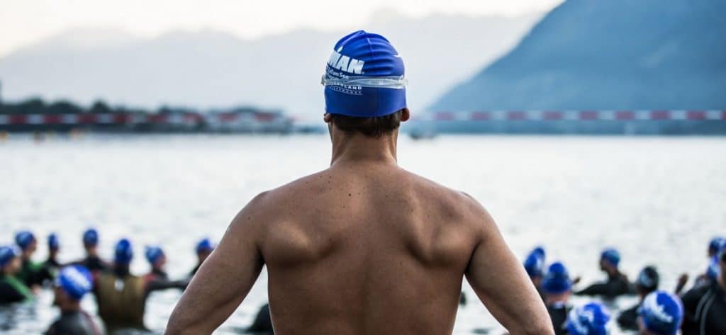 A swimmer with strong shoulders back facing the camera.
