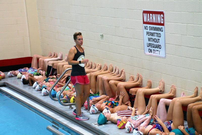 Coach Abbie Fish training young swimmers during a swim camp.