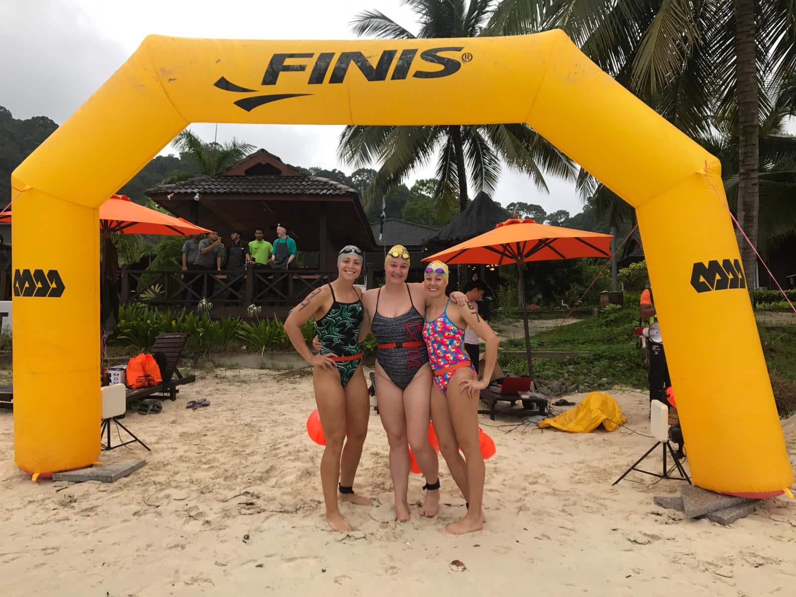 Abbie Fish with two team members standing by an inflatable Finis entrance arch.