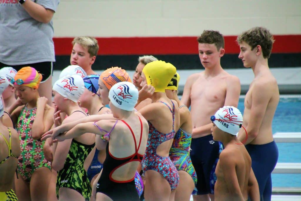 A group of young swimmers at an age group swimming competition.