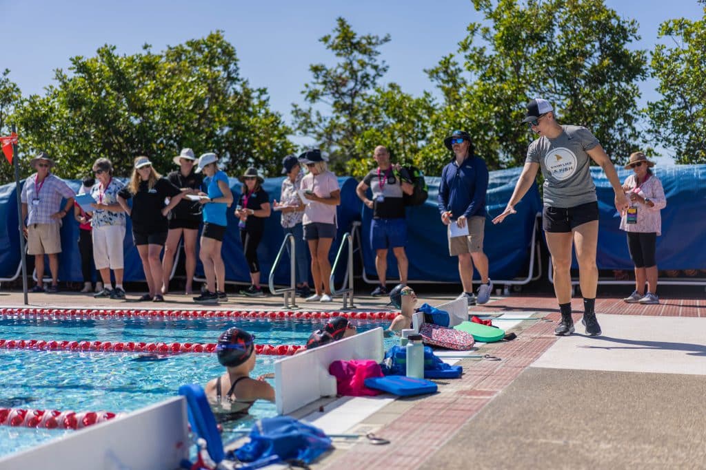 Abbie Fish with swim coaches and swimmers during an outdoor swim clinic.