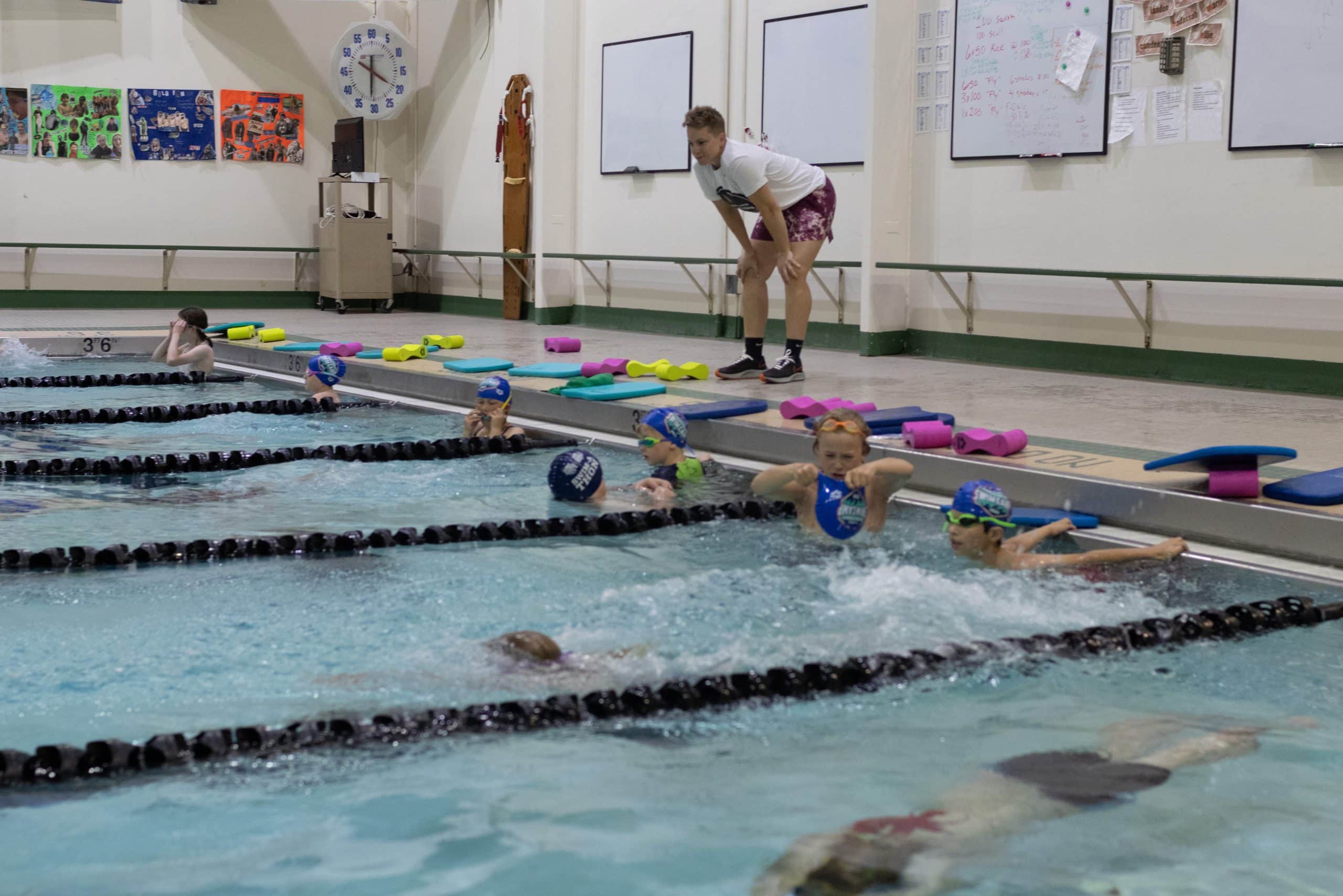 Abbie Fish swim coach and mentor on swimming session in the pool with age-groups swimmers