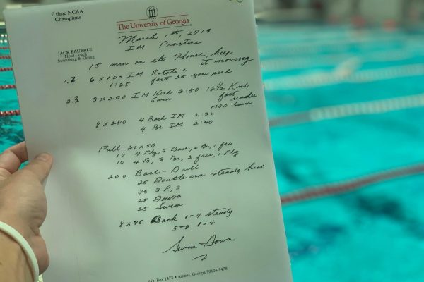 A custom swim workout written on a notepad.