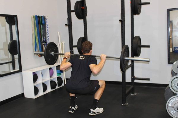 A Swim Like A. Fish swim coach lifting weights during a dryland training routine.