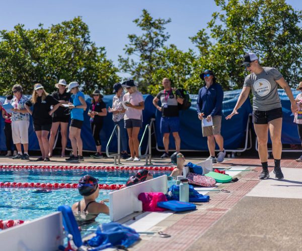 Abbie Fish with swim coaches and swimmers during an outdoor swim clinic.